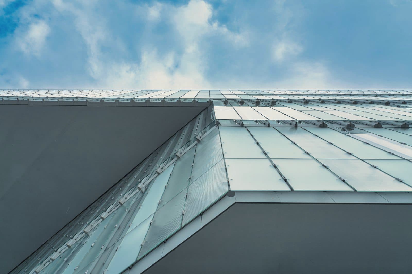 Glass façade and canopy of a modern building against blue sky