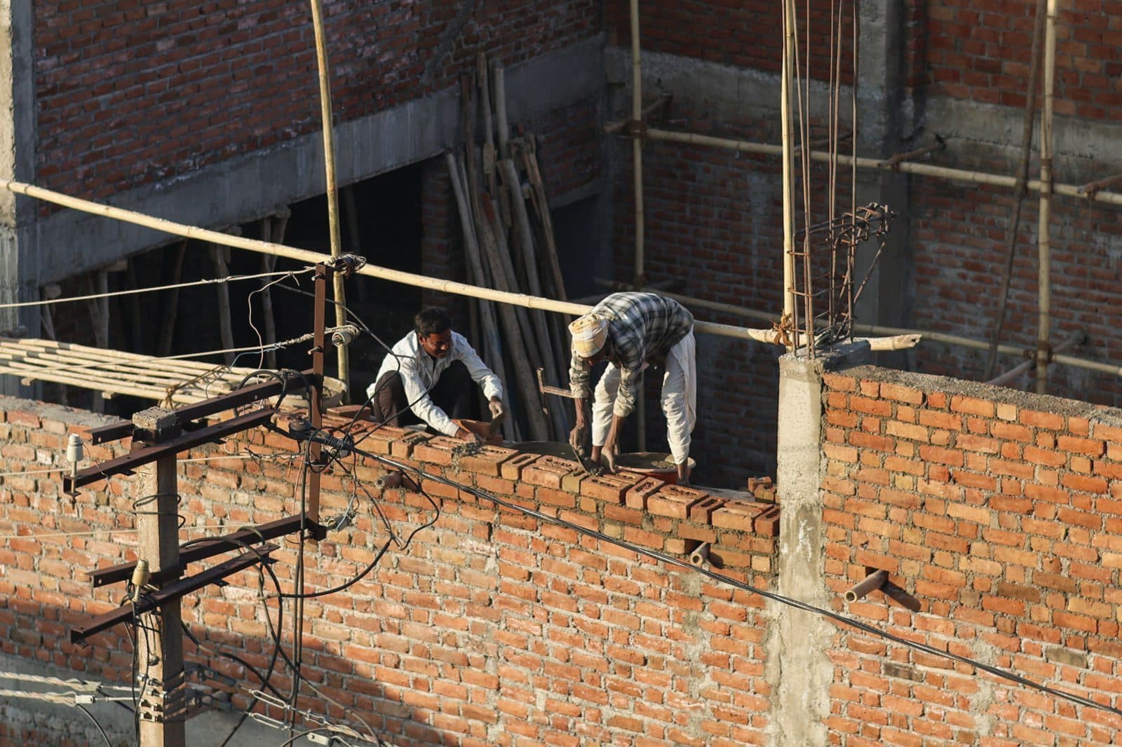 Masons building a brick wall on a multi-storey site