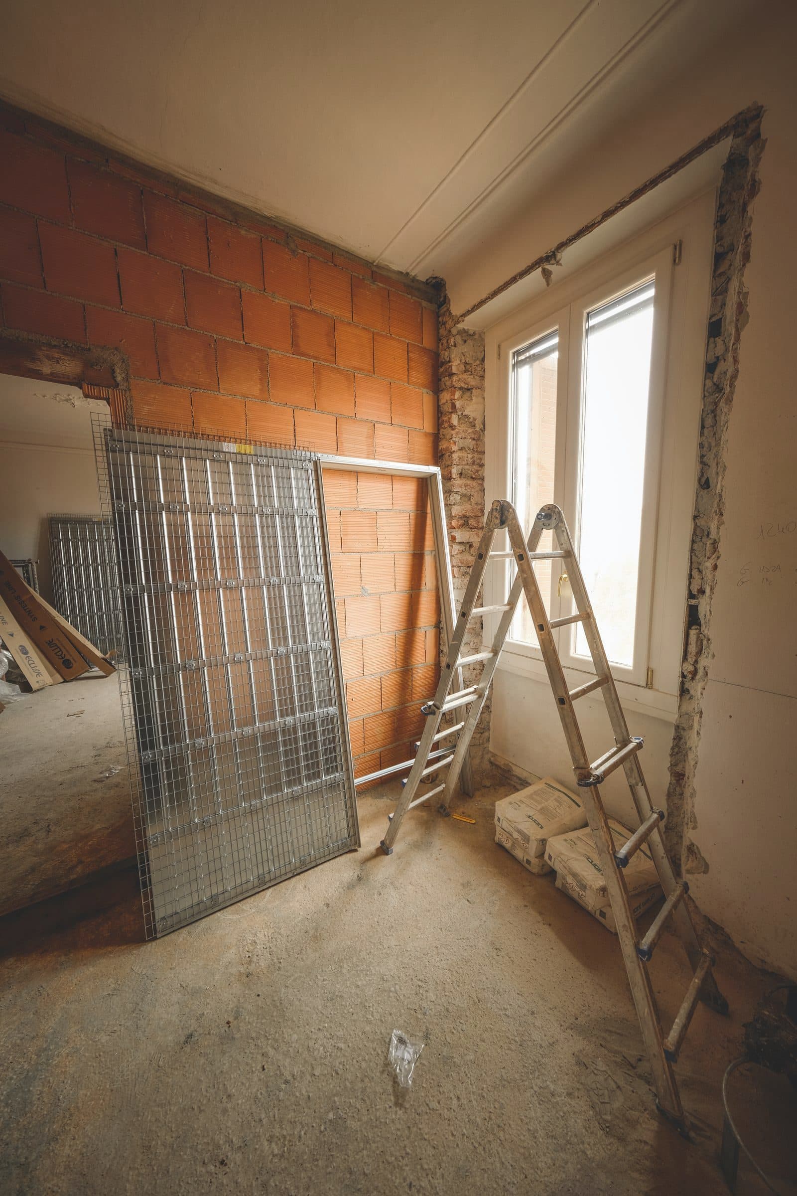 Interior under refurbishment with ladders and exposed brick